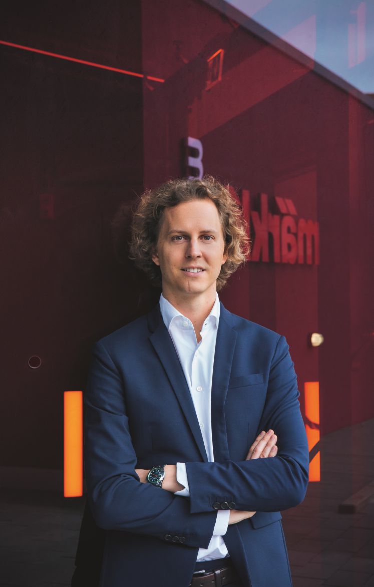 Florian Sieber mit verschränkten Armen in die Kamera lächelnd