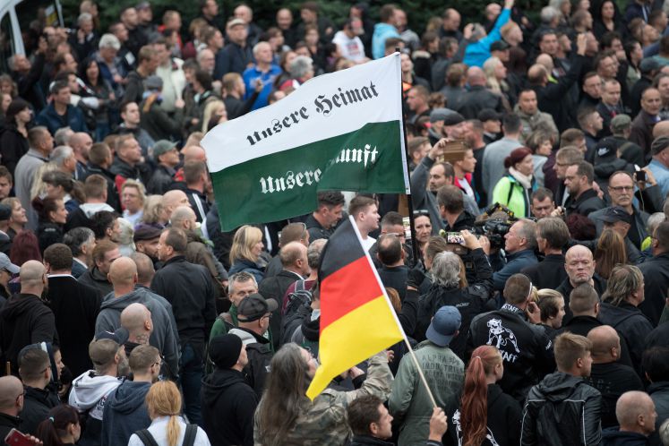 01.09.2018, Sachsen, Chemnitz: Die Teilnehmer der Demonstration von AfD und dem ausländerfeindlichen Bündnis Pegida, der sich auch die Teilnehmer der Kundgebung der rechtspopulistischen Bürgerbewegung Pro Chemnitz angeschlossen haben, warten auf den Start ihres Marsches durch die Stadt. Sie tragen u.a. eine Fahne mit der Aufschrift "Unsere Heimat unsere Zukunft" mit sich.