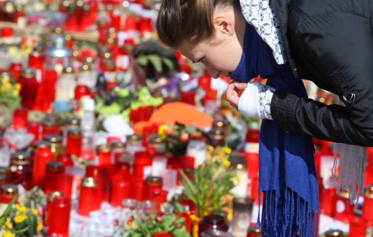 Eine junge Frau beugt sich am Samstag (21.03.2009) in Winnenden vor der Albertville-Realschule über ein Meer aus Kerzen und Blumen. Der 17-jährige Tim K. hatte am 11.03.2009 an seiner früheren Schule, der Albertville-Realschule in Winnenden und auf der Flucht nach Wendlingen fünfzehn Menschen und sich selbst erschossen. Am Samstag 21.03.2009 fand in Winnenden die offizielle Trauerfeier statt