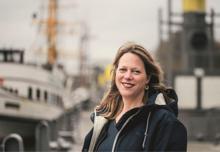 Maike Schaefer steht am Hafen und laechelt in die Kamera