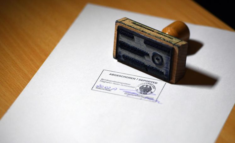 Der Schriftzug Abgeschoben/Deported steht in Schönefeld (Brandenburg) auf einem amtlichen Stempelbild der Bundespolizei