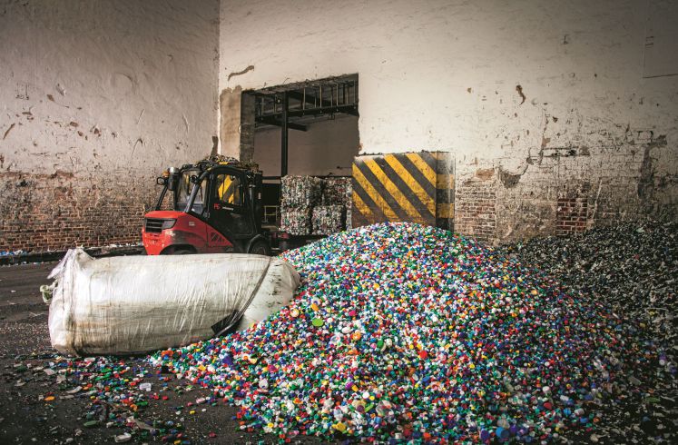 Gabelstabler vor einem großen Haufig Plastik
