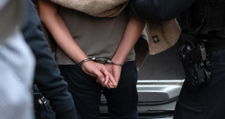 27.08.2018, Berlin: Polizisten führen einen verdächtigen Mann nach einer Razzia gegen kriminelle Mitglieder arabischer Großfamilien in der Pohlstraße ab