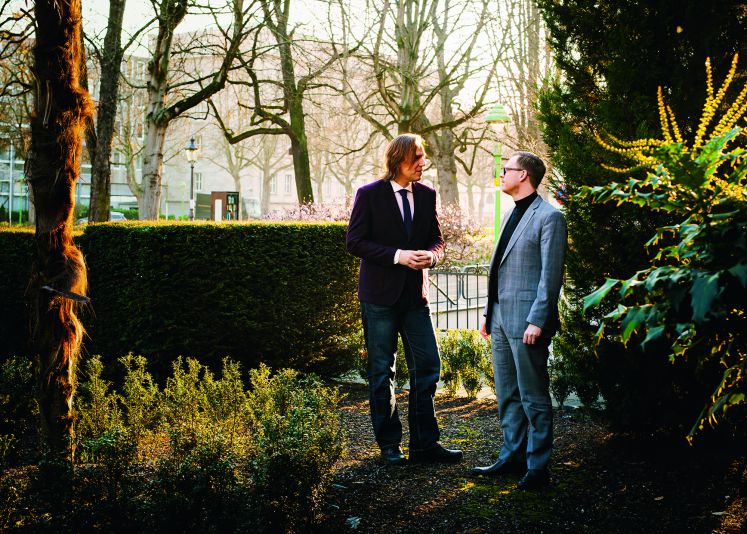 Stefan Lorenz Sorgner und Markus Gabriel stehen in einem Garten und diskutieren