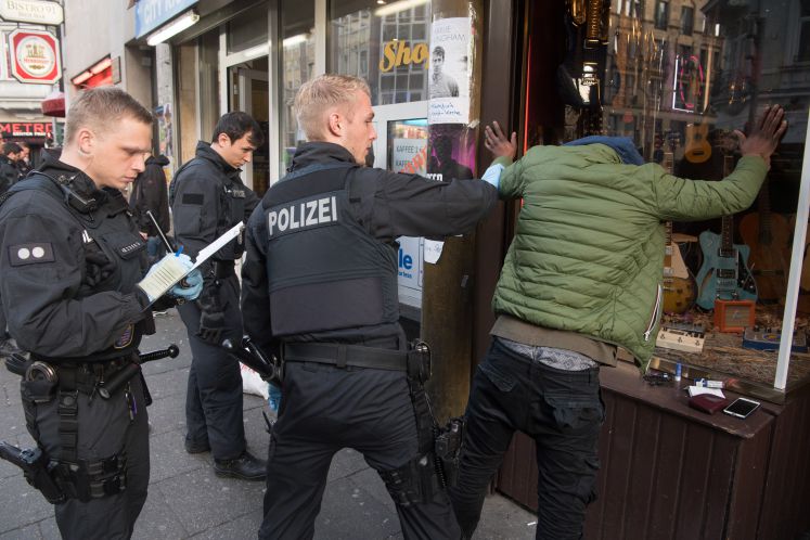 Polizisten nehmen einen tatverdächtigen Ausländer fest