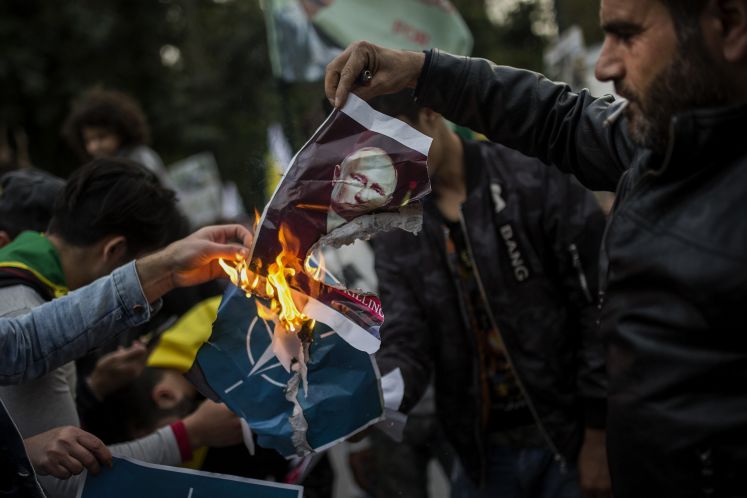 Demonstranten in Athen verbrennen ein Bild von Putin und dem Symbol der Nato