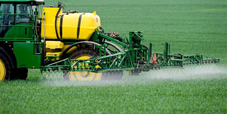 Ein Landwirt düngt seinen Acker mit Pflanzenschutzmittel