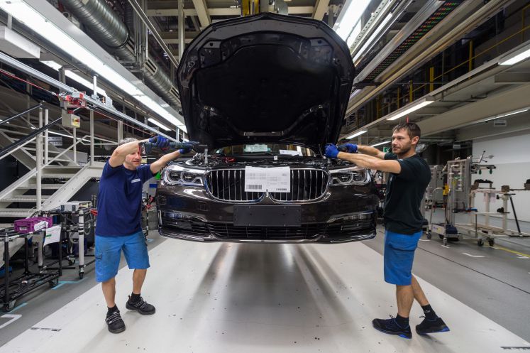 Mitarbeiter montieren im BMW-Werk in Dingolfing (Bayern) eine Frontschürze an einem Auto der 7er-Reihe, 