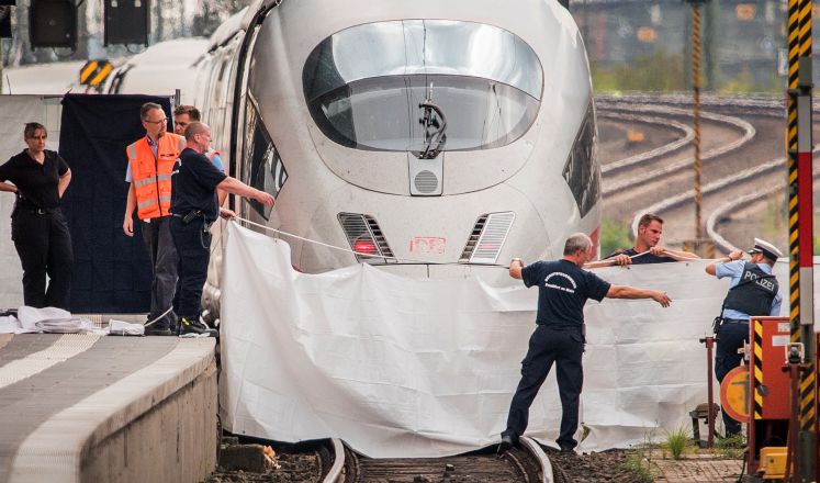 29.07.2019, Hessen, Frankfurt/Main: Polizisten und Feuerwehrleute spannen im Hauptbahnhof eine weiße Plane als Sichtschutz vor einen ICE. Ein achtjähriger Junge ist im Frankfurter Hauptbahnhof von einem Mann vor den einfahrenden ICE gestoßen und getötet worden. Ein Tatverdächtiger wurde festgenommen, wie die Polizei mitteilte. Der Mann soll auch die Mutter des Jungen ins Gleisbett gestoßen und es bei einer weiteren Person versucht haben.