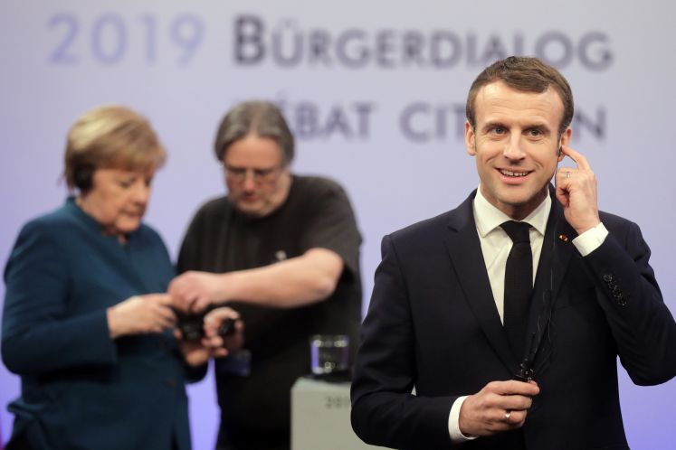 Macron vorne, Merkel im Hintergrund