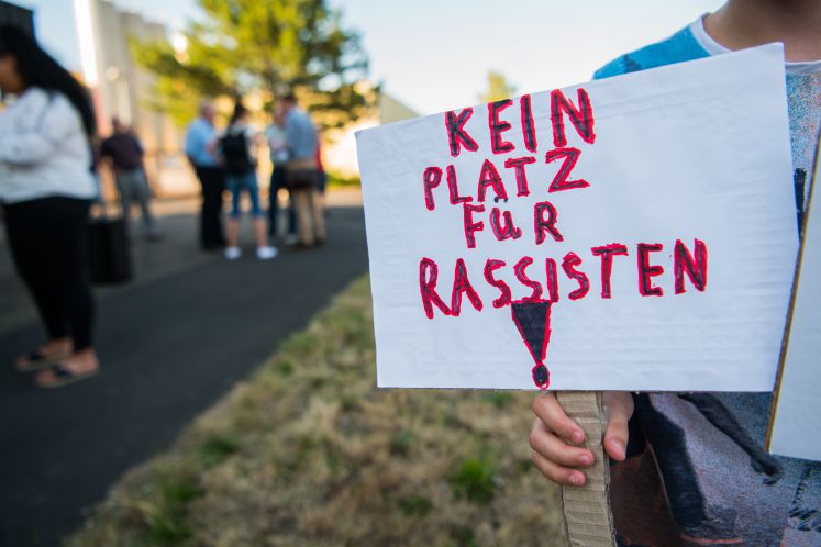 23.07.2019, Hessen, Wächtersbach: Ein Junge hält bei der Mahnwache „Kein Platz für Rassismus“ ein Schild gegen Rassismus. Ein 26 Jahre alter Mann aus Eritrea war in Wächtersbach von Schüssen schwer verletzt worden. Der mutmaßliche Täter, der inzwischen im Krankenhaus verstorben ist, hat möglicherweise aus einem fremdenfeindlichen Motiv heraus gehandelt.