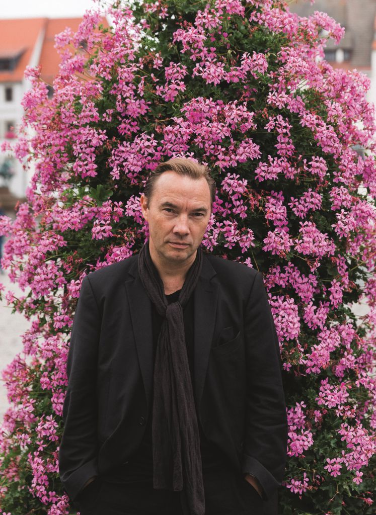 Thomas Arnold vor einem rosa Blütenstrauch