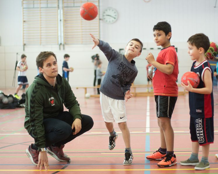 Willy Weyhrauch von den Füchsen Berlin unterstützt beim Sportunterricht einer Willkommensklasse an der Grundschule am Fließtal am 17.02.2016 in Berlin. Die Berliner Profivereine 1. FC Union, ALBA, BR Volleys, Eisbären, Füchse und Hertha BSC unterstützen die Integration von Willkommensklassen im Schulsport. Die Clubs bieten seit Herbst 2015 feste, wöchentliche Sportangebote für Willkommensklassen an, mittlerweile werden darüber ca. 500 Flüchtlingskinder in 39 Willkommensklassen erreicht.