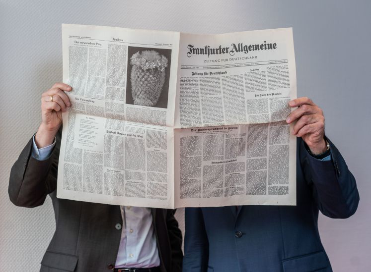 Carsten Knop, Chefredakteur Digitale Produkte (l), und Berthold Kohler, Herausgeber der Frankfurter Allgemeinen Zeitung (FAZ, r), stehen in den Redaktionsräumen hinter einem Exemplar der ersten FAZ-Ausgabe vom 01.11.1949. 