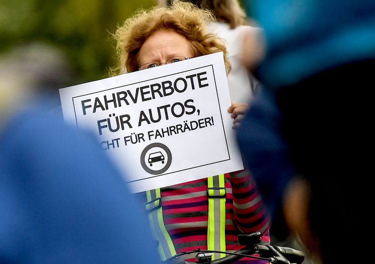28.05.2019, Berlin: Eine Demonstrantin zeigt ein Schild mit der Aufschrift "Fahrverbote für Autos, nicht für Fahrräder" auf der Oberbaumbrücke. Wegen Bauarbeiten ist eine Fahrbahn der Brücke gesperrt. Radfahrer werden aufgefordert, abzusteigen und das Fahrrad über den Gehweg zu schieben. Gegen die angeordnete Absteigepflicht und den Autoverkehr wird nun demonstriert. 