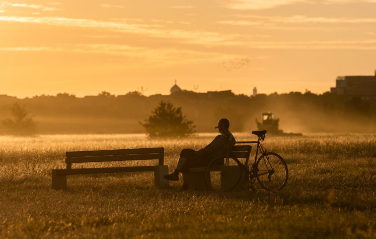 13 August 2018, Germany, Berlin: A man enjoys the morning atmosphere in the light of the rising sun on the Tempelhofer Feld.