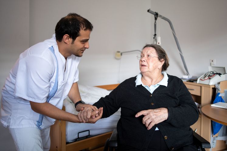 2.09.2018, Nordrhein-Westfalen, Neuss: Altenpfleger Amera Kabara unterhält sich in der Seniorenresidenz Curanum mit der Bewohnerin Elisabeth Grohmann. (zu dpa: "Ärzte- und Pflegemangel: Zuwanderung als Rezept gegen Kollaps?") 