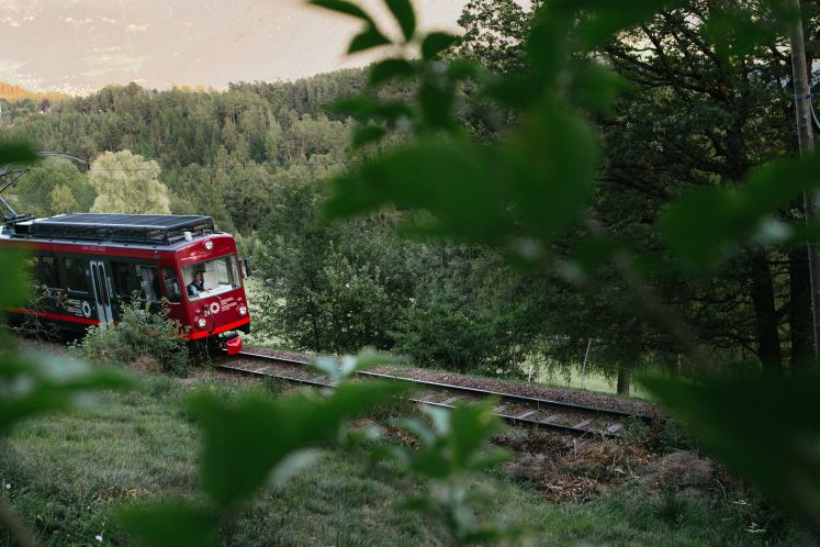 Triebwagen der Rittner-Bahn, die durch Landschaft fährt