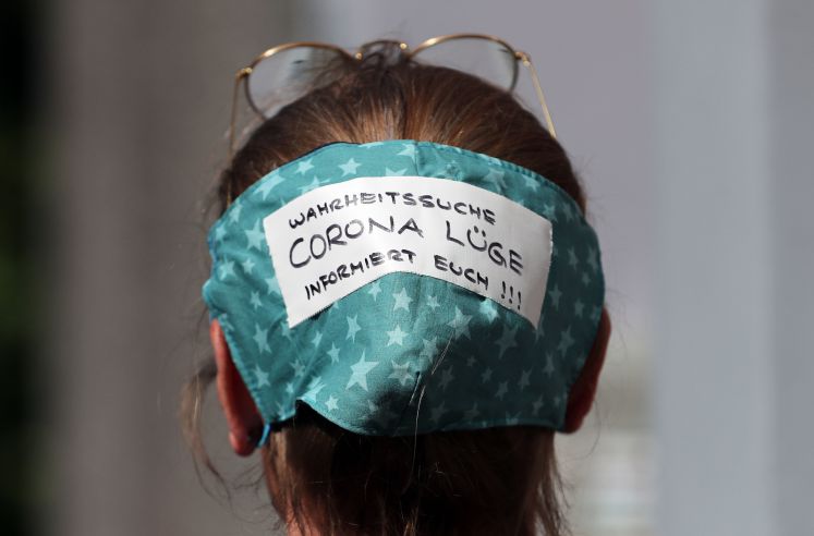 Kann ein Virus lügen? Kopfschmuck einer Demonstrantin am 1. Mai/dpa