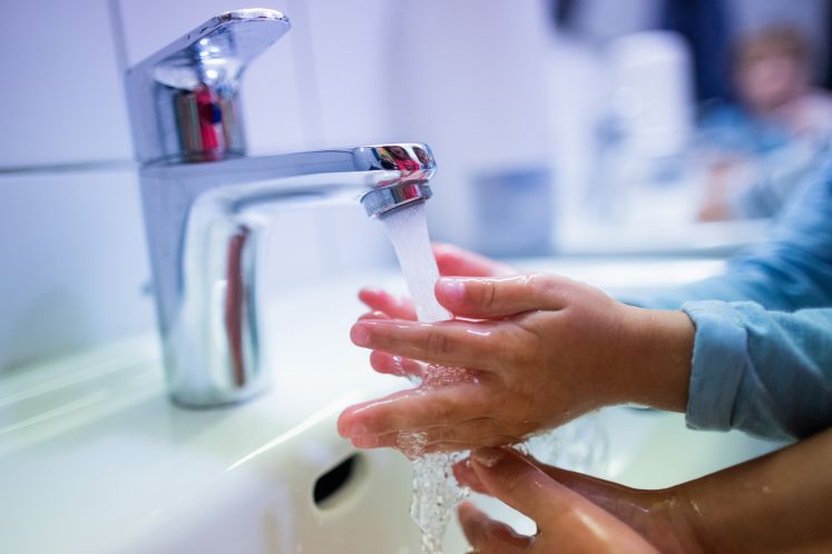 Kind wäscht seine Hände