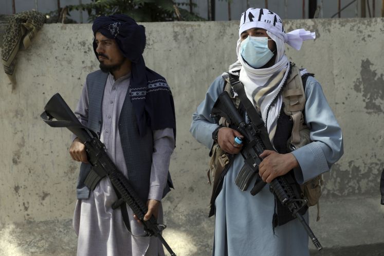 Taliban-Kämpfer stehen am Haupttor zum Präsidentenpalast Wache. Das US-Militär hatte am Montag, 16.08.2021, Mühe, eine chaotische Evakuierung aus Afghanistan zu bewältigen, während die Taliban in der Hauptstadt patrouillierten und versuchten, nach dem Sturz der vom Westen unterstützten Regierung Ruhe zu vermitteln.