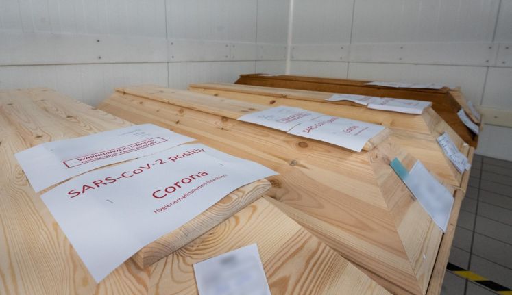 Särge mit Warnhinweisen zu Sars-Cov-2