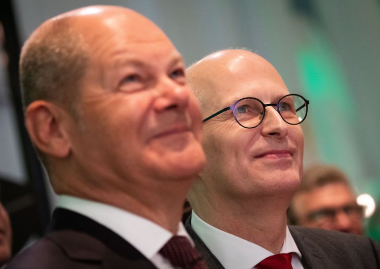 Olaf Scholz und Peter Tschentscher blicken lächeln nach oben