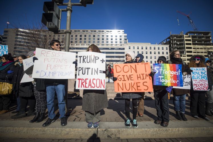 Demonstranten halten Schilder während einer Demonstration gegen die Wahl von Präsident Donald Trump durch das Nationale Wahlmännerkollegium vor dem Wilson Building in Washington, DC, USA, 19. Dezember 2016