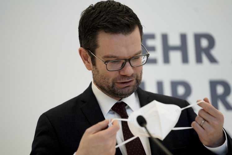 Marco Buschmann setzt sich eine Maske auf