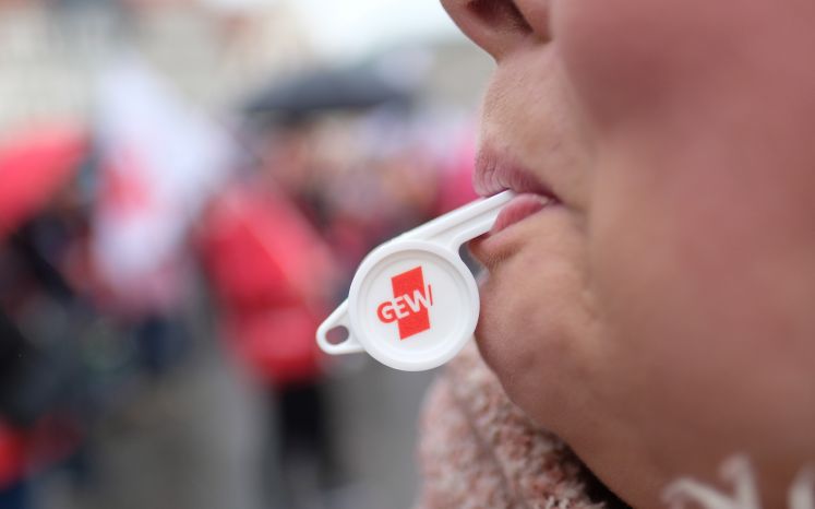 Eine Teilnehmerin einer Kundgebung der Gewerkschaft Erziehung und Wissenschaft (GEW) mit einer Trillerpfeife.