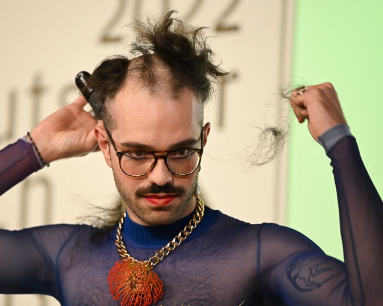 Kim de l'Horizon rasiert sich nach der Auszeichnung mit dem Deutschen Buchpreises 2022 im Frankfurter Römer die Haare ab / dpa