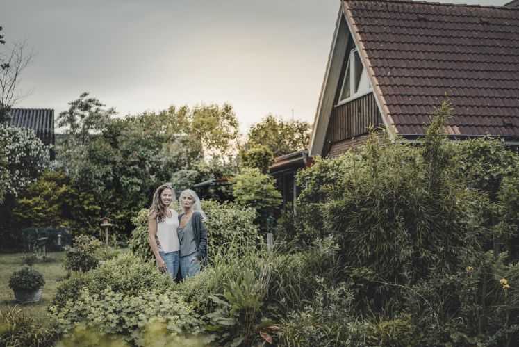 Zwei Frauen im Garten vor Einfamilienhaus