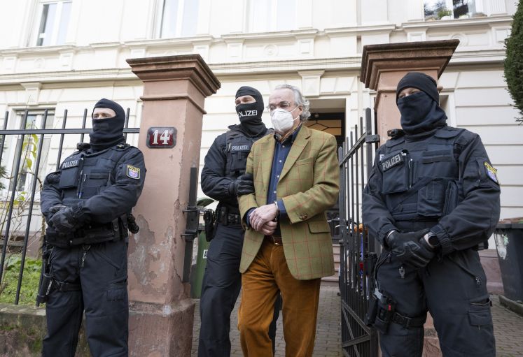 Bei einer Razzia gegen sogenannte Reichsbürger führen vermummte Polizisten, nach der Durchsuchung eines Hauses Heinrich XIII Prinz Reuß (2.v.r.) zu einem Polizeifahrzeug.