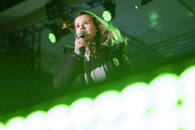 Luisa Neubauer mit Mikrofon auf der Bühne am Brandenburger Tor