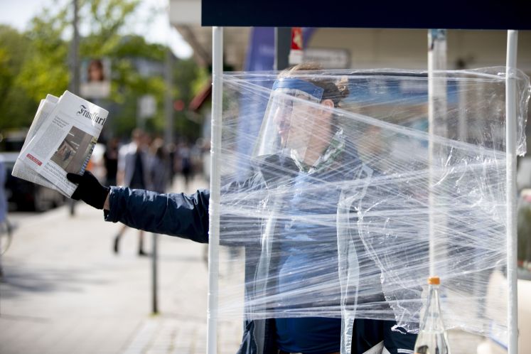 Ein FAZ-Verkäufer mit Gesichtsschutz / dpa