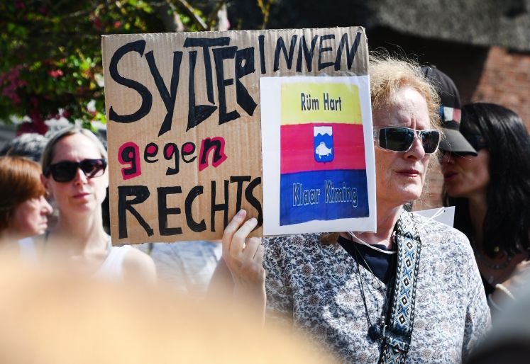SylterInnen gegen Rechts“ steht auf einem Schild, dass eine Frau bei einer Mahnwache in der Hand hielt. 