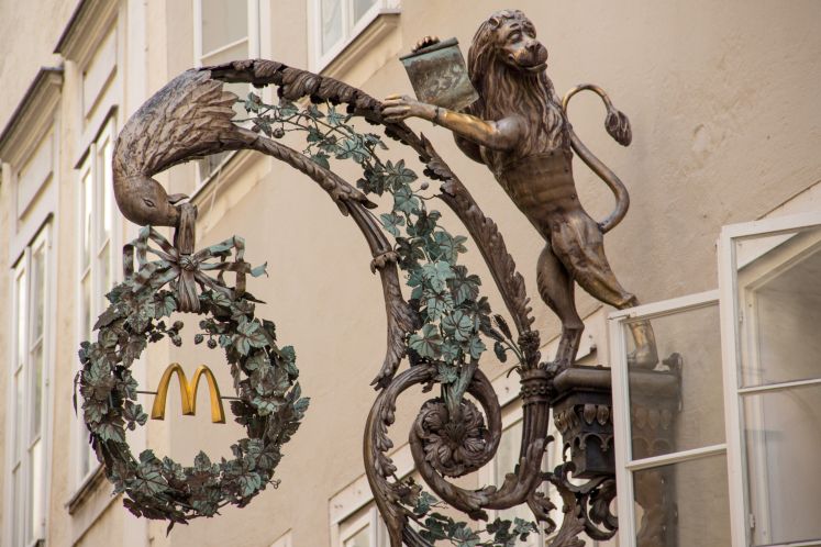 Schmiedeeisernes Zunftzeichen an McDonalds Filiale in der Getreidegasse in Salzburg.