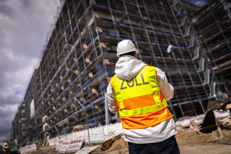 Ein Zollbeamter steht an einer Baustelle bei einer Ueberpruefung zum Thema Schwarzarbeit in Berlin,