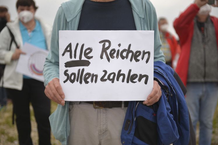 Plakat mit der Aufschrift "Alle Reichen sollen zahlen"