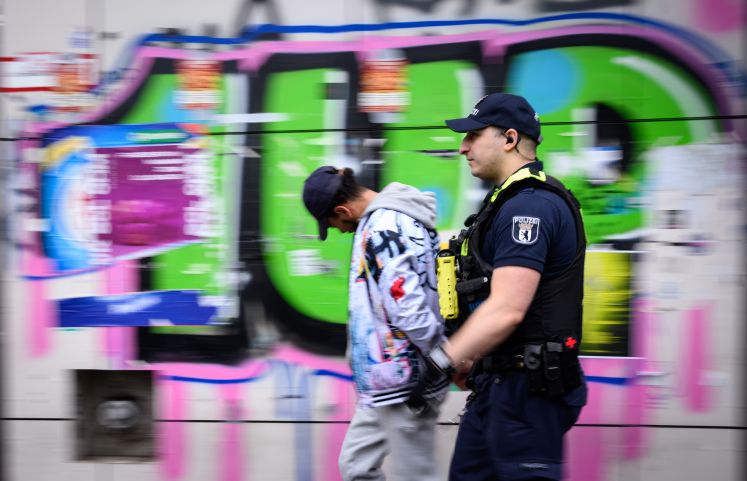 Ein Polizeibeamter der Brennpunkt- und Präsenzeinheit (BPE) der Polizei Berlin führt am Kottbusser Tor in Kreuzberg einen mutmaßlichen Drogen-Dealer ab
