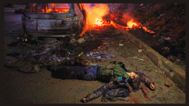 Der Leichnam einer SDF-Kämpferin liegt neben einem brennenden Auto, nachdem syrische Regierungstruppen die Stadt von den kurdisch geführten, US-unterstützten SDF übernommen haben