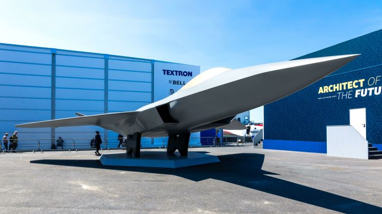 Foto eines grauen, modernen Tarnkappenflugzeugs auf einem Messegelände bei Sonnenschein