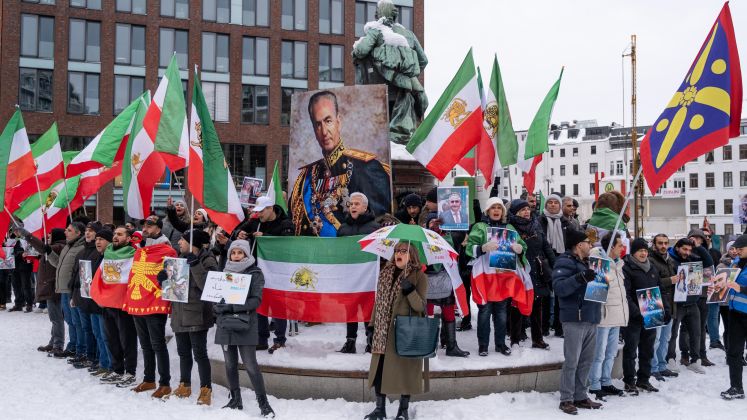 Foto: Menschenmenge mit iranischen Fahnen, großem Schah-Porträt, winterliche Stadt