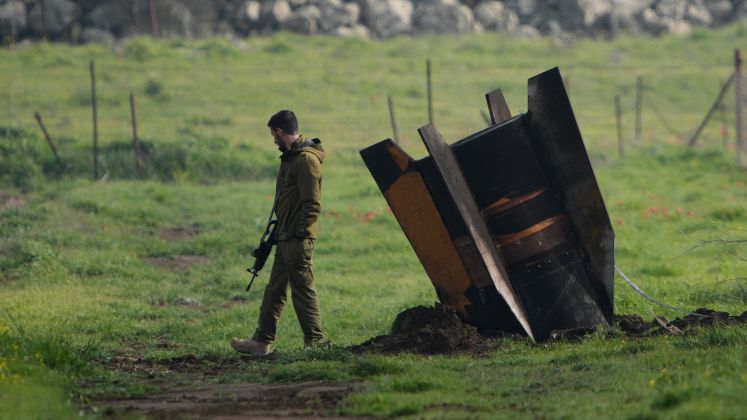 Ein Soldat mit Gewehr geht im Grünen neben einer schwarzen Barriere, unsicherer Vorschlag. Foto.