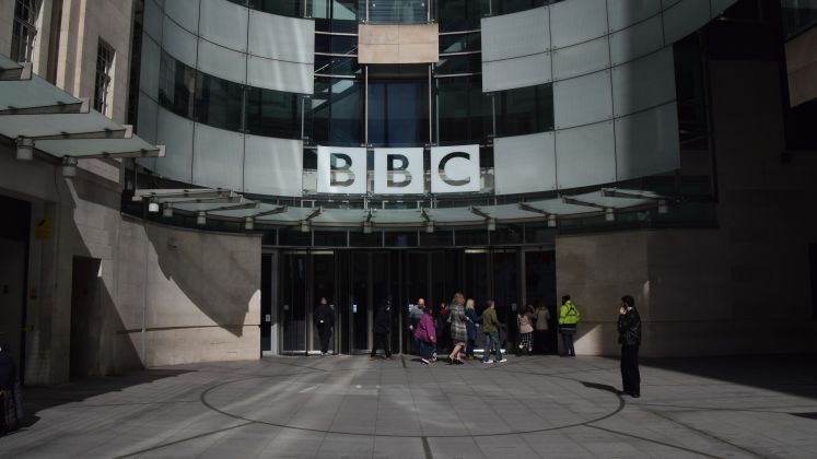 Foto: BBC-Gebäude mit Glassfassade, mehrere Menschen stehen vor dem Eingang.