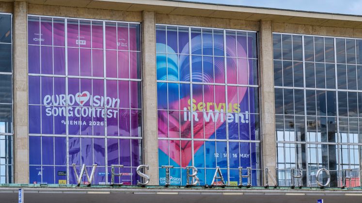 Großes, buntes Plakat mit Herz auf Glasfassade am Wiener Westbahnhof, keine Personen erkennbar, Foto.