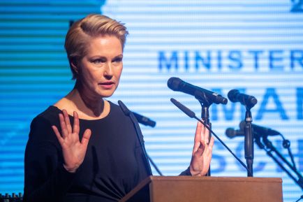 Manuela Schwesig steht am Podium und hat beide Hände wie bei einer Abwehrgeste gehoben