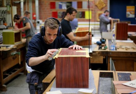 Ein Auszubildender zum Schreiner arbeitet am 21.06.2016 in Köln (Nordrhein-Westfalen) im Ausbildungszentrum Butzweilerhof an einer Holzkiste