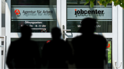 Junge Männer warten vor einem Jobcenter