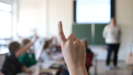 Ein Schüler der vierten Klasse meldet sich im Mathematikunterricht einer Grundschule